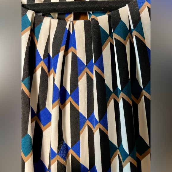 Sleeveless blouse with open pleats at neck and a small button on the back. - Picture 3 of 6